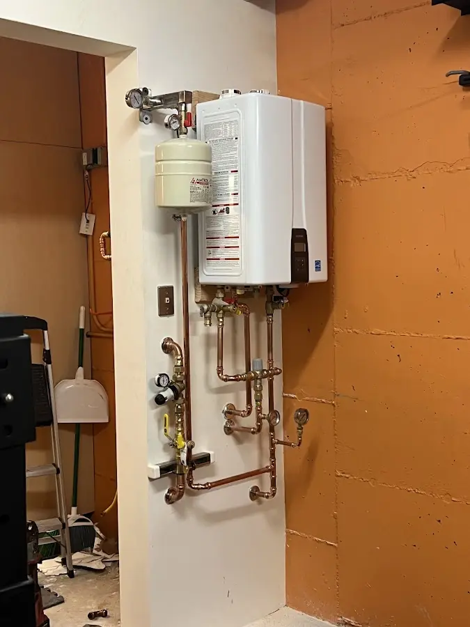 Plumbing technician inspecting water heater connections in Potomac Mills